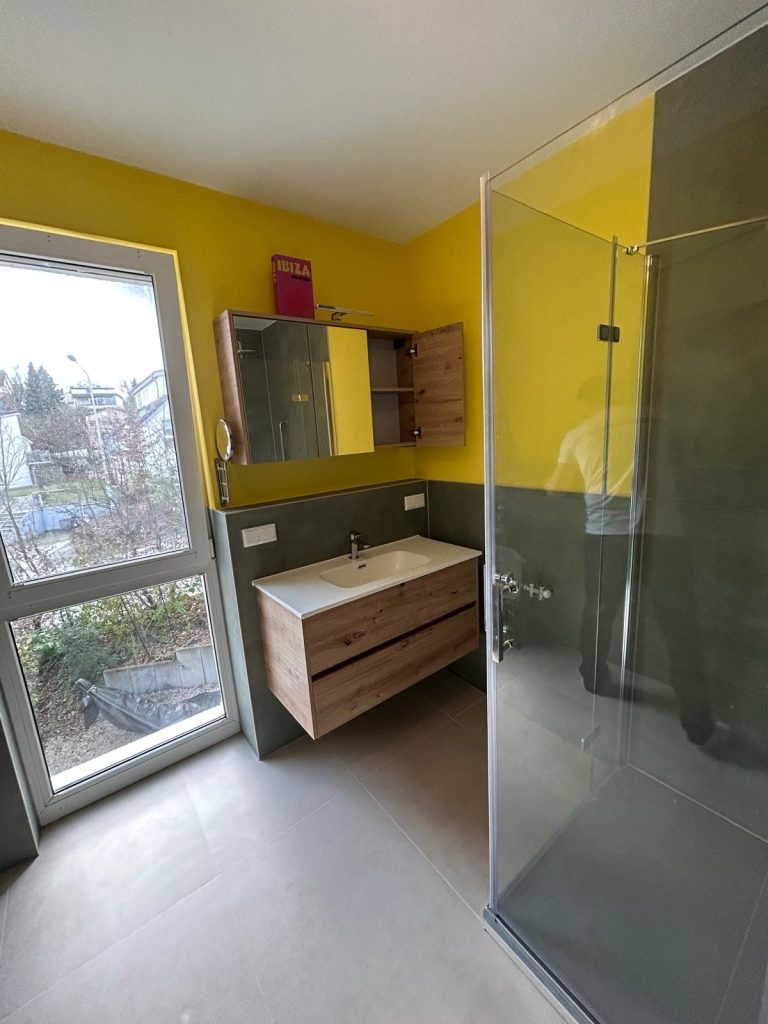 Modernes Bad mit Waschtisch in Holz und Grau, Spiegel und Glasdusche