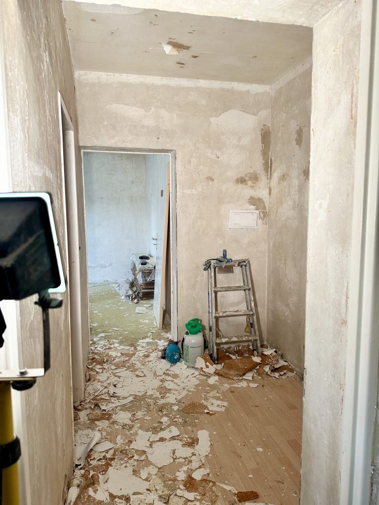 Schmaler Flur in Sanierung mit Klappleiter und abgelöster Tapete