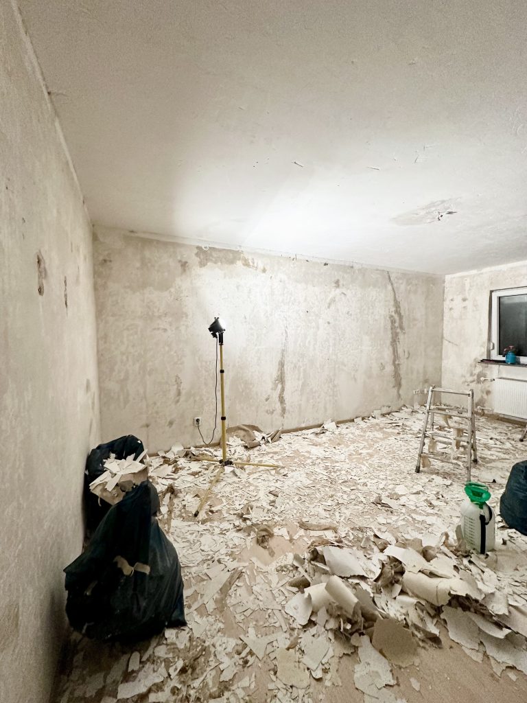 Leerer Raum in Sanierung mit nacktem Putz und Bauschutt