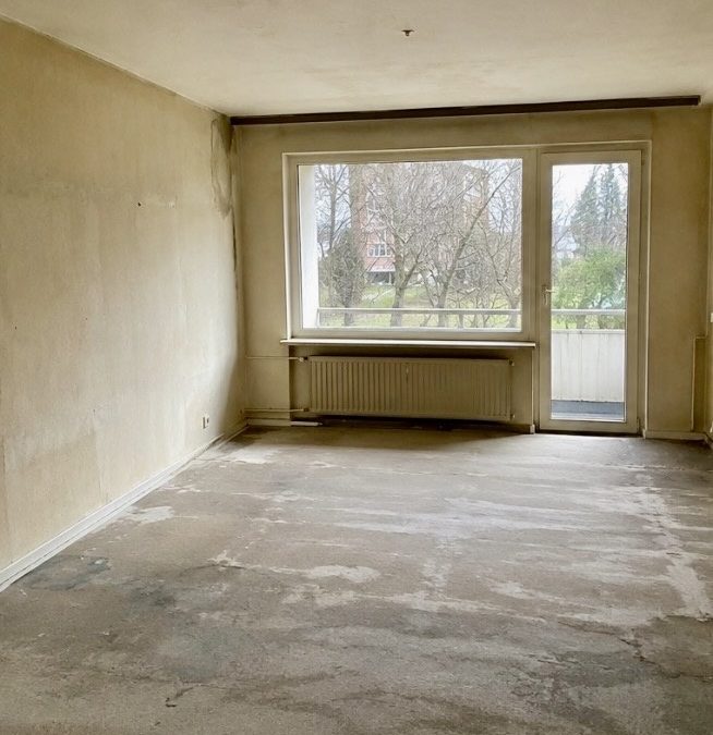 Unsanierter leerer Raum mit nackten Wänden und Estrichboden