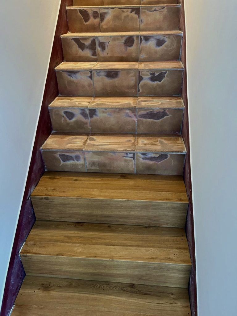 Treppe mit Übergang von gefliesten Stufen zu Holzstufen