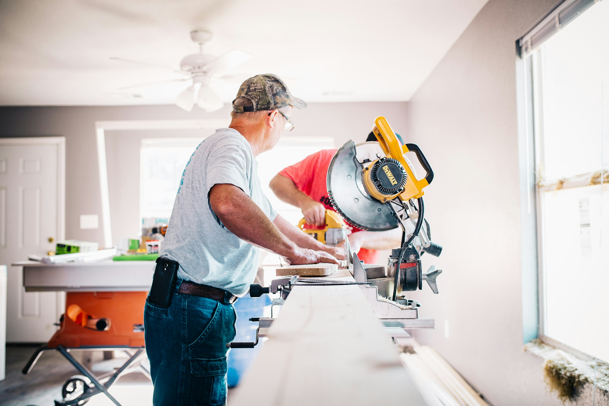 Zwei Handwerker schneiden im Innenausbau Leisten auf einer Kappsäge zu