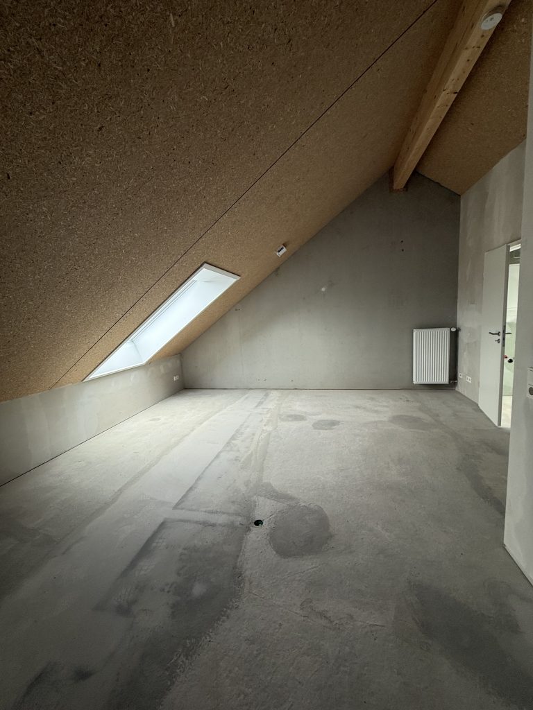 Dachraum im Rohbau mit OSB-verschalter Dachschräge und Dachfenster