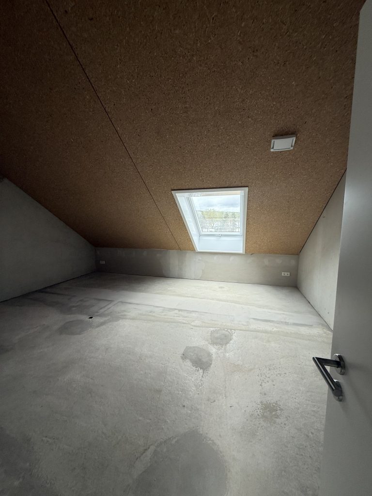 Dachraum im Rohbau mit OSB-verschalter Decke und Dachfenster