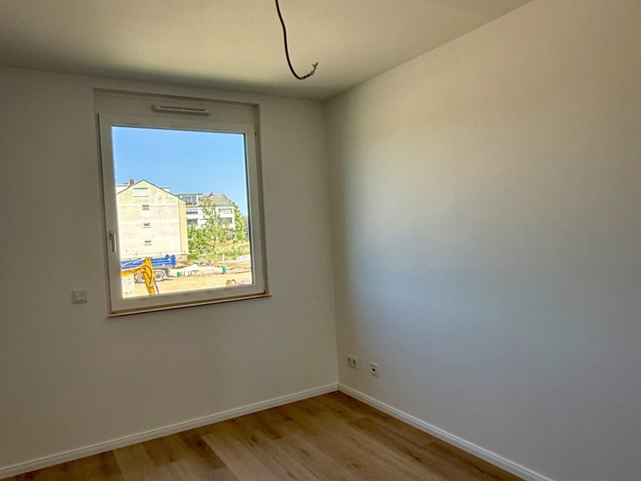 Leerer weißer Raum mit Fenster und Vinylboden in Eichenoptik